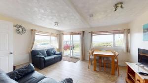 a living room with a couch and a table at C37 Jupiter, Riviere Towans in Hayle