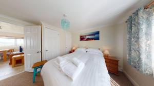 a bedroom with a white bed with white pillows at C37 Jupiter, Riviere Towans in Hayle