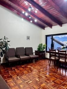 ein Wartezimmer mit Stühlen, einem Tisch und einem Fenster in der Unterkunft Departamento tranquilo con terraza privada in Riobamba