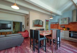 een keuken en woonkamer met een tafel en stoelen bij DREAM COLOR in Alignan-du-Vent