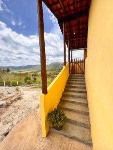 een trap naar een gebouw met een gele muur bij Sítio Vista da Serra - Carrancas in Carrancas +64 foto's