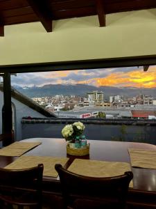 ein Esszimmer mit Tischen und Blick auf die Stadt in der Unterkunft Departamento tranquilo con terraza privada in Riobamba + 5 Fotos