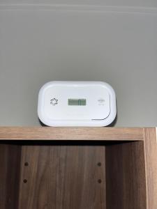 un orologio digitale appoggiato su un tavolo di legno di Appartamento Elena a Parma