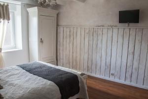 a bedroom with a bed and a tv on a wall at Le coup de coeur in Coincy +1 photo