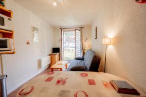 een kamer met een bed, een stoel en een raam bij Studio Cabine Ax Les 3 Domaines in Ax-les-Thermes