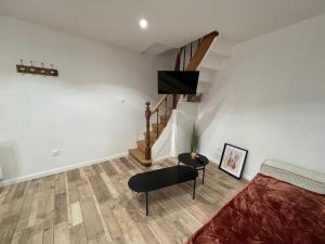 een slaapkamer met een bed, een stoel en een trap bij Maison avec courette in Courlay