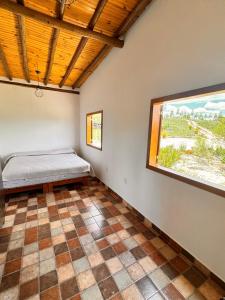 ein Schlafzimmer mit einem Bett und einem Fenster in der Unterkunft Sítio Vista da Serra - Carrancas in Carrancas