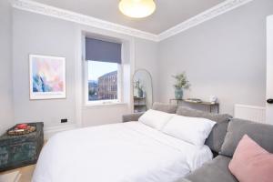 sala de estar blanca con sofá y ventana en The Portside Apartment, en Greenock