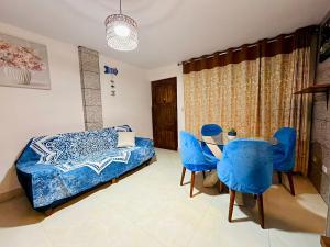 Schlafzimmer mit einem Bett und einem Tisch mit blauen Stühlen in der Unterkunft Comfortable House in Punta Hermosa