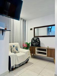 ein Wohnzimmer mit einem Stuhl und einem Flachbild-TV in der Unterkunft Comfortable House in Punta Hermosa