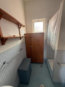a bathroom with a toilet and a wooden door at A casa do Amor in Vila do Maio