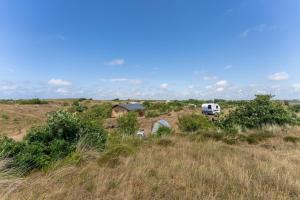 a camper van parked in the middle of a field at DuinHut with Hottub in Ons Belang
