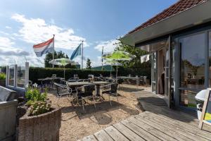 a patio with tables and chairs and umbrellas at DuinHut with Hottub in Ons Belang