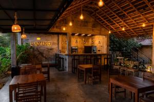 a restaurant with wooden tables and chairs and a bar at Shehani Beach Bungalow in Tangalle