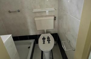 a bathroom with a toilet with a sign on it at DuinHut with Hottub in Ons Belang