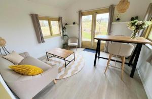 a living room with a couch and a table at DuinHut with Hottub in Ons Belang