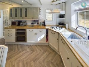 een keuken met witte kasten en een spoelbak bij Sea Salt - Beer, East Devon in Beer