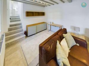 een woonkamer met een bruine leren bank en een trap bij Sea Salt - Beer, East Devon in Beer