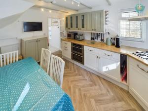 een keuken met witte kasten en een tafel met stoelen bij Sea Salt - Beer, East Devon in Beer