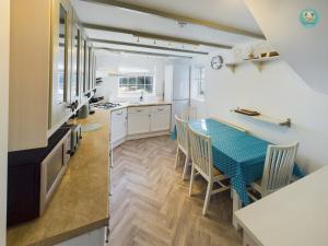 een keuken en eetkamer met een tafel en stoelen bij Sea Salt - Beer, East Devon in Beer +7 foto's