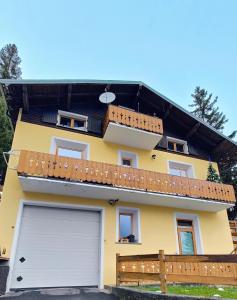 a yellow house with a white garage door at Casa Producena in Valdidentro