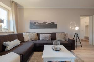 a living room with a brown couch and a table at DünenZeit in List
