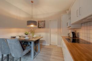 a kitchen with a table and chairs in a room at DünenZeit in List +31 photos
