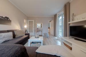a living room with a couch and a flat screen tv at DünenZeit in List