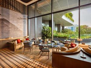 海防Pullman Hai Phong Grand Hotel的一家有桌椅和大窗户的餐厅