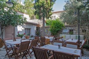 a patio with tables and chairs in a courtyard at Lilyum Alaçatı - Taş Ev in Alacati