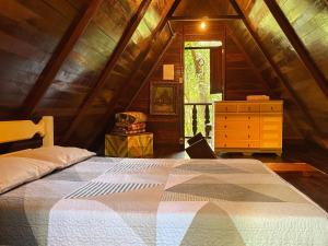 una camera da letto con un letto grande in una mansarda di Chalé Floresta Amada a Ouro Preto Altre 36 foto
