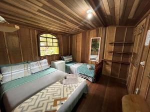 una camera con 2 letti in legno di Tekoah Pousada a Paranaguá