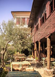 a patio with tables and chairs next to a building at Hunnap Han in Küçükkuyu