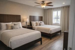 a bedroom with two beds and a ceiling fan at Venice Inn Motel in Venice