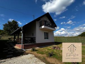 een klein huis met een bord ervoor bij Estina Hill in Tamási