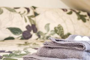 een stapel handdoeken bovenop een bed bij Pebbles Guest House - Flat 5 in Southampton
