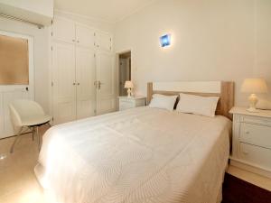 um quarto branco com uma cama branca e uma cadeira em Apartment in Lagos em Lagos