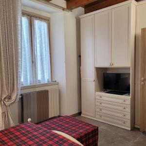 a bedroom with a tv and a cabinet with a television at Eva Lake Endine Hospitality in Endine Gaiano