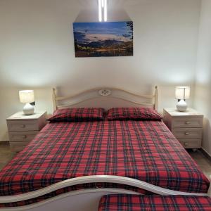 een slaapkamer met een geruit bed en 2 nachtkastjes bij Eva Lake Endine Hospitality in Endine Gaiano