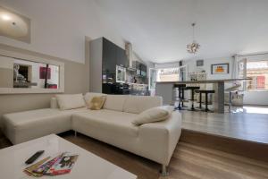 een woonkamer met een witte bank en een keuken bij Black & White in Alignan-du-Vent