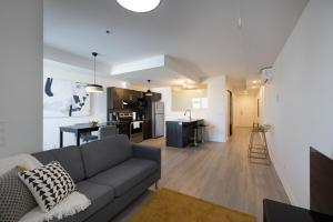 a living room with a couch and a kitchen at Buchanan 609 - Midtown Condo Luxe and Gym in Montréal