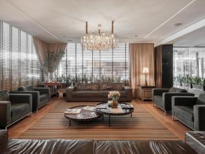 a living room with couches and a chandelier at Faial Prime Suítes in Florianópolis