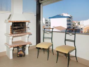 duas cadeiras e um banco numa varanda em Apartment in Lagos em Lagos