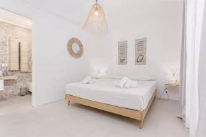 a white bedroom with a bed and a mirror at Casa Nouè in Tertenìa +32 photos