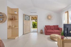a living room with a red couch and a tv at Casa Nouè in Tertenìa