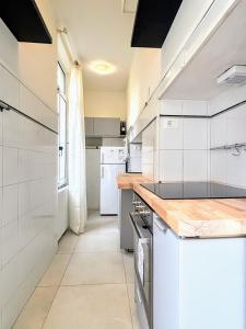 eine weiße Küche mit einer Theke und einem Kühlschrank in der Unterkunft Luxury Home Massa - Free Parking - City center in Massa + 5 Fotos