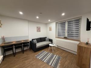 a living room with a couch and a table at ApartmentsByMatyrafa-XIV in Tarnowskie Góry +9 photos