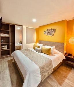 a bedroom with a large bed with a yellow wall at Hotel Buena Vista in Bucaramanga