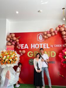 a man and a woman standing in front of a sign at Tea hotel by Chiến Hảo in Ha Giang