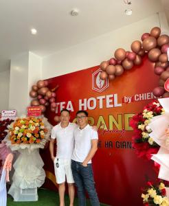 a group of three men standing in front of a sign at Tea Hotel by Chien Hao in Ha Giang